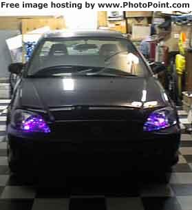 A car with aftermarket purple-glowing headlights