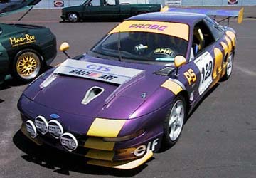 A purple-and-yellow riced-out Ford Probe race car